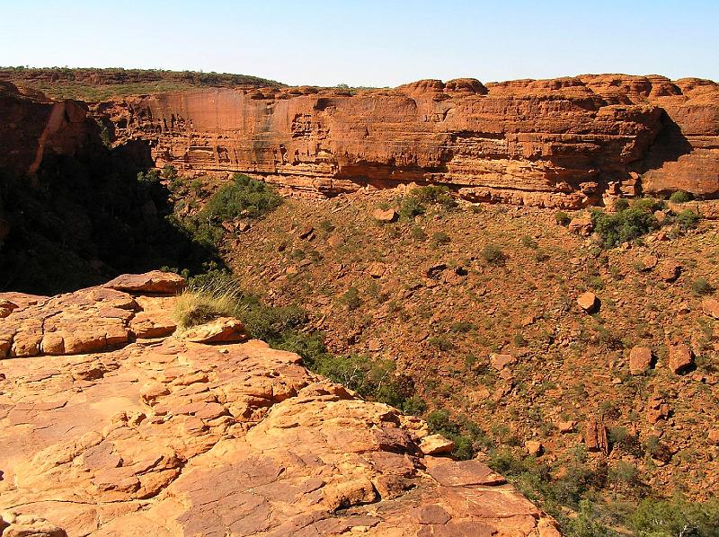 Kings Canyon4.jpg - Die Felswände des Kings Canyon bestehen aus rotem und gelbem bis weißem Sandstein. Die Wände des Canyons sind teilweise über 300 m hoch. Der Sandstein, dessen rote und gelbliche Farbe aus Eisenoxiden (Hämatit und Limonit) resultiert, ist stark kleinteilig zerklüftet und bildet interessante Strukturen aus unterschiedlichen Farben und Zeichnungen. Erosion von Sonne und Wind mit Sand hinterlässt verrundete Formen.